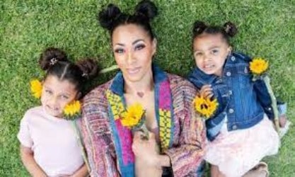 Amina Buddafly with her both daughter posing with sunflowers. They seems very happy 